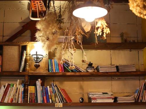 a shelf full of books in a room at Guesthouse Hitoyado in Shizuoka