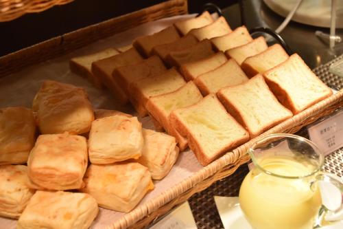 a tray of bread on a table with a tray of milk at Dormy Inn Premium Otaru in Otaru