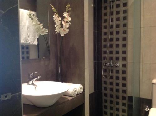 a bathroom with a sink and a shower at Galaxy City Hotel in Limenas