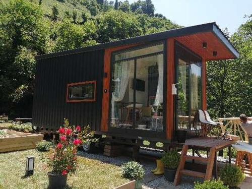 a black and orange tiny house in a yard at Vagona Tiny House in Rize