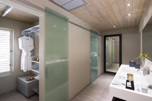 a bathroom with a shower, sink, and toilet at South Point Antigua in English Harbour Town