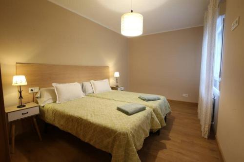 1 dormitorio con 1 cama grande con manta verde en Apartamento Oviedo Foncalada, en Oviedo