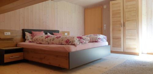 a bedroom with a bed with pink sheets on it at Haus Feuerstein in Schnepfau