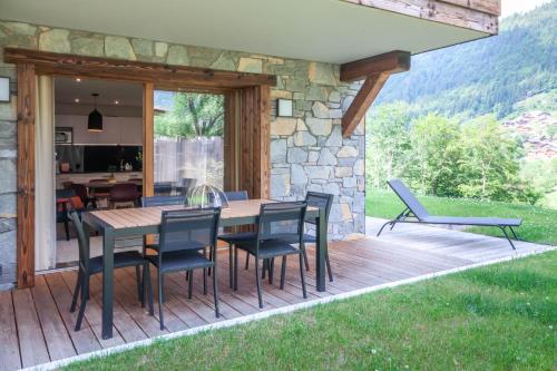 une terrasse en bois avec une table et des chaises sur une maison dans l'établissement Lapia 1, à Morzine