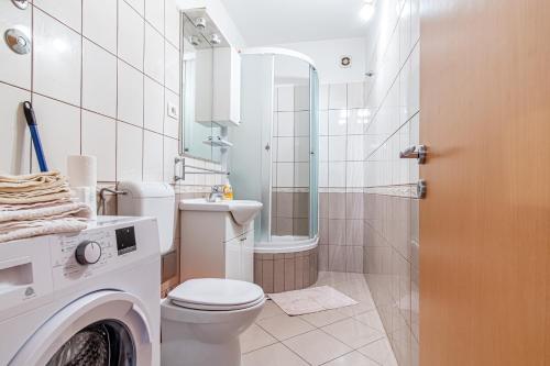 a bathroom with a toilet and a sink and a washing machine at Apartment Goge in Split