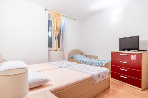a small bedroom with a bed and a tv at Apartment Goge in Split