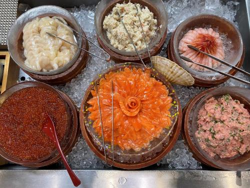 a bunch of different types of food in bowls at Dormy Inn Premium Otaru in Otaru