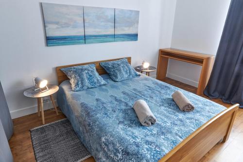 - une chambre avec un lit bleu et 2 oreillers dans l'établissement Centre ville à pied Appt avec SAUNA, Linge, Wifi, Stationnement Gratuit, à Vannes
