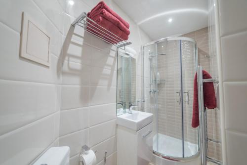 a white bathroom with a shower and a sink at Casa San Carlo in Valletta