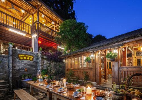 einen Essbereich im Freien mit einem Tisch und einem Gebäude in der Unterkunft Yangshuo Secret Garden in Yangshuo