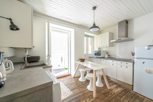 une cuisine avec des armoires blanches et un plancher en bois dans l'établissement Les Échoppes, à Annecy