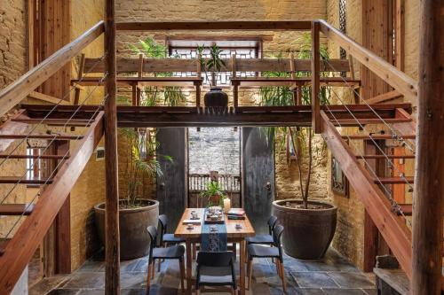 a room with a table and chairs and wooden stairs at Yangshuo Secret Garden in Yangshuo