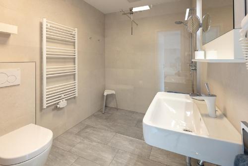 uma casa de banho com um lavatório branco e um WC. em Haus Wolff am Meer em Ahlbeck