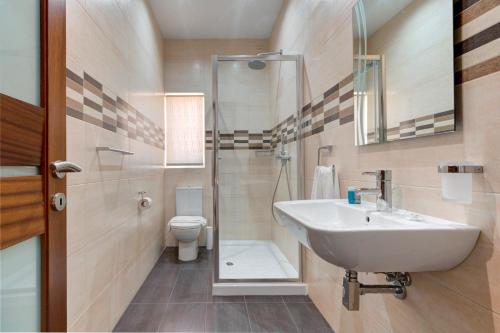 uma casa de banho com um lavatório e um WC em Modern Seaside 2 BR APT w Spectacular Views em St. Paul's Bay