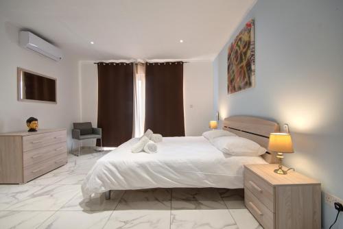 a bedroom with a bed and a desk and a chair at Modern Beach APT w Fantastic Sea Views - 1 in Mellieħa