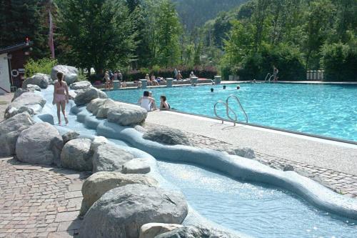 una piscina con rocce e persone in acqua di Gemütliches Apartment in Landeck a Landeck
