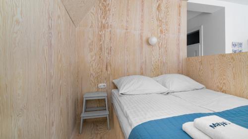 - une chambre avec un lit et un mur en bois dans l'établissement Maya's Flats & Resorts 37 - Piwna, à Gdańsk