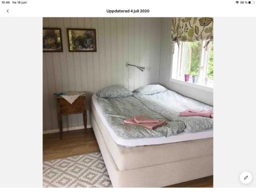 Un dormitorio con una cama con toallas rosas. en Stråvalla Hulegården en Stråvalla