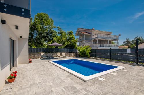- une piscine dans l'arrière-cour d'une maison dans l'établissement Apartments Villa "Aurea" with pool, à Krk