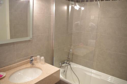 La salle de bains est pourvue d'une douche, d'un lavabo et d'une baignoire. dans l'établissement Brise de Mer, à Porto Ota