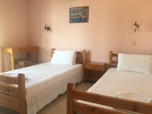 twee bedden in een kamer met twee tafels bij Nikolas Apartments Yianna, Kalami bay sea view in Kalámi