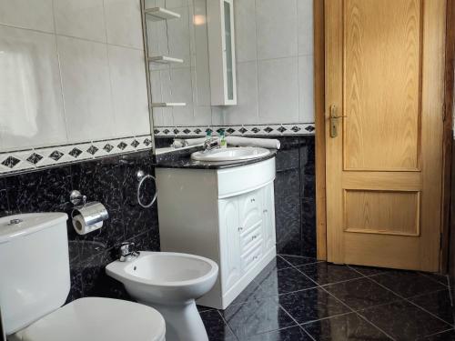 een badkamer met een wit toilet en een wastafel bij Casa do Meia Noite in Gralhas