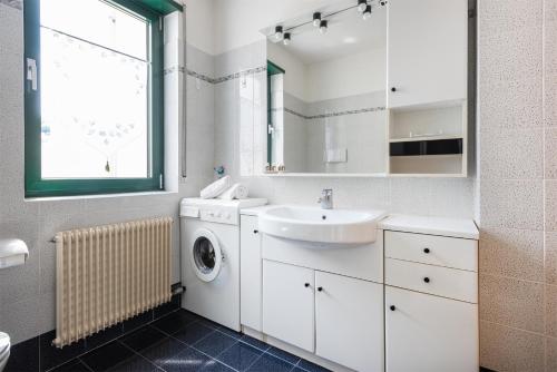 baño blanco con lavadora y lavamanos en Brione paradise, en Riva del Garda