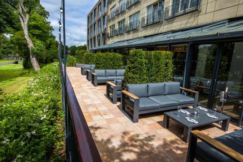 a row of couches and tables in front of a building at Herbert Park Hotel and Park Residence in Dublin