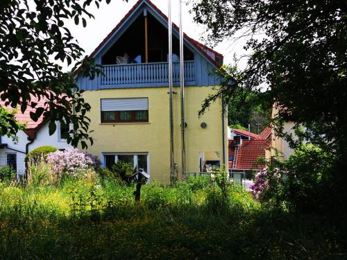 Una casa amarilla con balcón en la parte superior. en Ferienwohnung Brigitte, en Reichelsheim