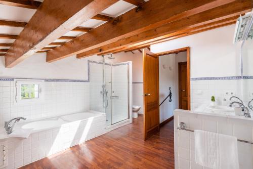 a bathroom with a tub and a shower and a sink at Finca Na Bona in Mahón