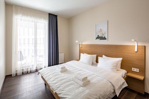 ein Schlafzimmer mit einem großen Bett mit weißer Bettwäsche und einem Fenster in der Unterkunft Новобудова в центрі Львова in Lwiw