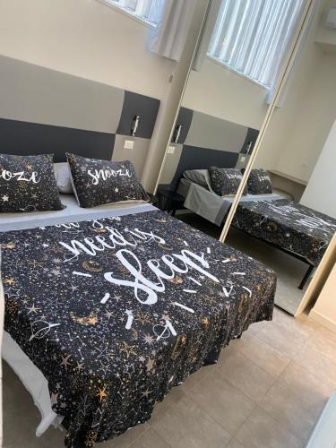 una camera da letto con due letti e uno specchio di la via lattea a La Spezia