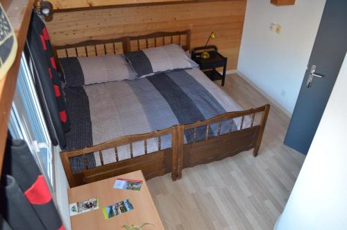 a bedroom with a wooden bed with a wooden floor at Logement chez l'habitant étage indépendant in Grône