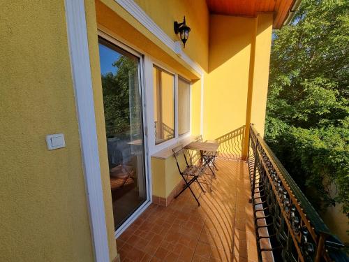 d'un balcon d'une maison jaune avec une fenêtre. dans l'établissement Abigél Vendégház, à Miskolctapolca