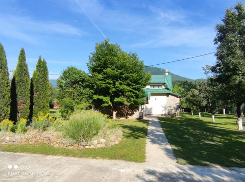 uma casa com um telhado verde e uma entrada em Mila Holiday Home em Lohovo