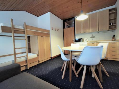 a small room with a table and chairs and a bunk bed at Apartma Svizec Rogla in Zreče