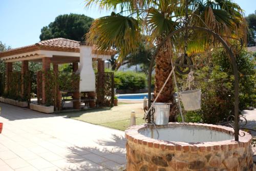 a fountain with a palm tree in a yard at Magnifica Planet Costa Dorada in Cambrils
