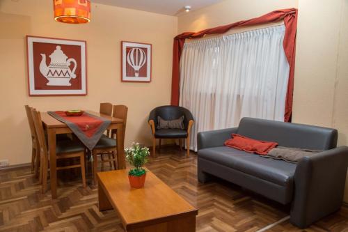 ein Wohnzimmer mit einem Sofa und einem Tisch in der Unterkunft King David Flat Hotel - Argentina in Cordoba