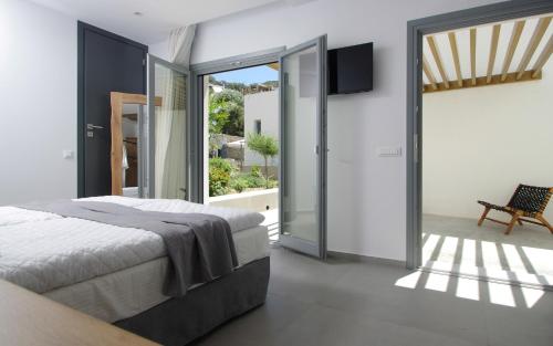 a bedroom with a bed and a sliding glass door at Oro Suites in Kinion