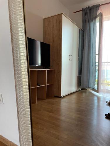 a living room with a tv and a wooden floor at Blue Sky Apartments in Slatine
