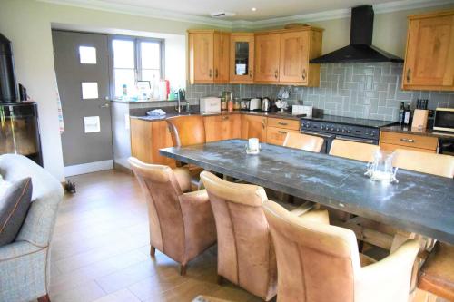 a kitchen with a large table and some chairs at Hideaway Lodge in Kingussie
