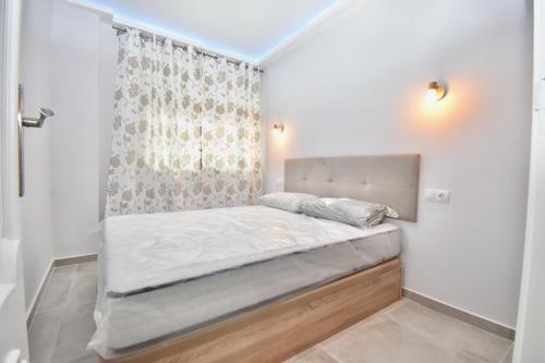 Cama pequeña en habitación con cortina en Luxury Suites Fuengirola, en Fuengirola