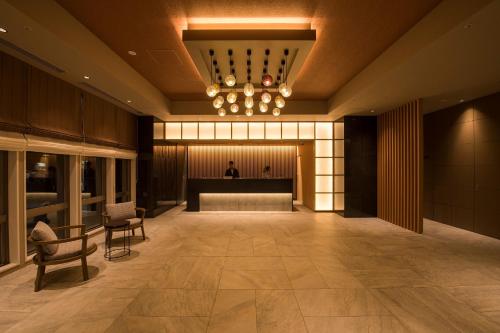 a lobby with a man standing in the background at Tmark City Hotel Sapporo Odori in Sapporo