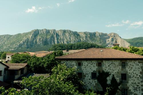 a building with a mountain in the background at La casa de Epi in Ziordia