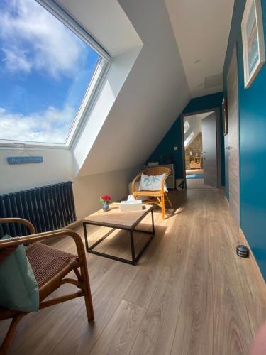 Cette chambre dispose d'une grande fenêtre et d'une table. dans l'établissement L’ARDOISIÈRE, maison d’hôtes et d’amis, à Locquirec