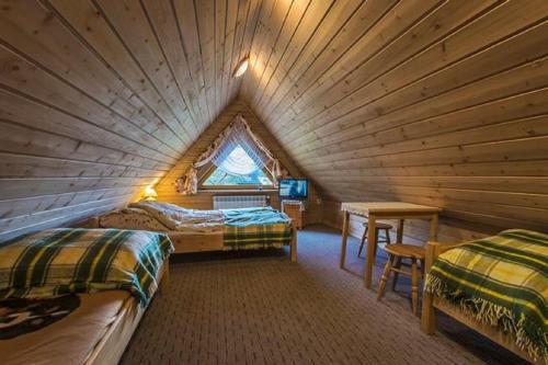 a bedroom with two beds in a log cabin at Domki Bacówka Pod Skocznią in Zakopane