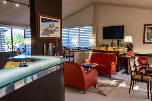 a hotel room with a pool table and chairs at Hotel & Spa Villa dei Mosaici in Spello