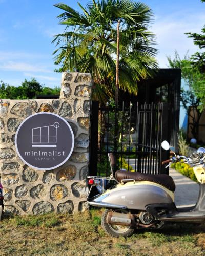 a scooter parked next to a stone wall with a sign at Minimalist Sapanca in Sapanca