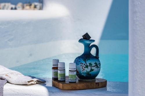 a blue vase and three small bottles on a table at Aegean Blue Suites in Pirgos