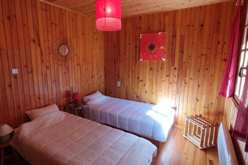 a bedroom with two beds in a wooden room at Chalet privé au Mont-Serein ventoux in Mont Serein